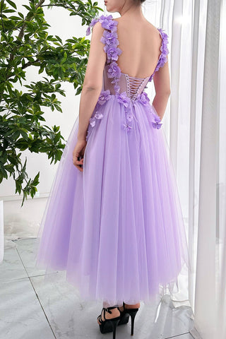 Designed for those who love bold colour and delicate details, this lavender dress features floral appliqués that bloom across the bodice and shoulders, creating a visually striking effect. The low-cut sweetheart neckline adds a hint of allure, while the full tulle skirt balances the look with softness and fluidity. Whether attending a garden party, a wedding, or a formal evening, this dress promises to make a stunning statement.