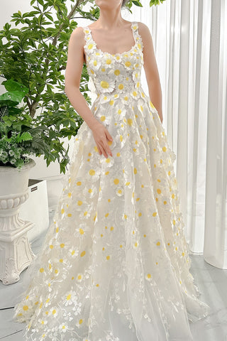 Elegant daisy-embroidered white gown with yellow floral accents, showcasing a romantic and whimsical look for nature-inspired celebrations or outdoor weddings