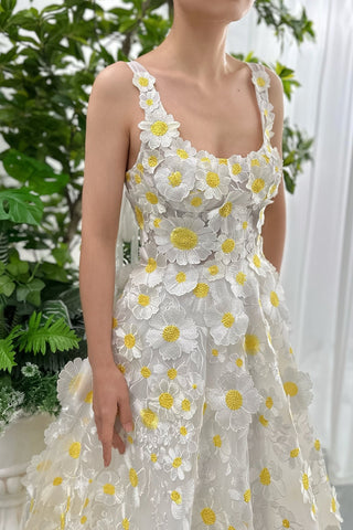 A stunning sleeveless white tulle dress adorned with intricate yellow daisy appliqués, perfect for spring weddings or garden parties, featuring delicate floral embroidery and a soft flowing design